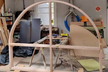 Custom round timber window frame in workshop